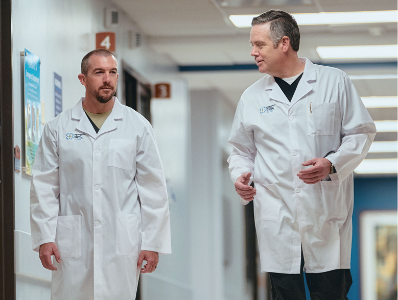 Two doctors walking down hallway talking to each other
