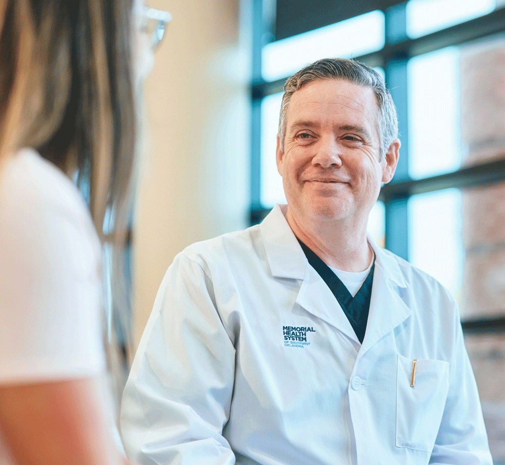 Male Memorial Health System doctor smiling while talking to patient Male Memorial Health System doctor smiling while talking to patient