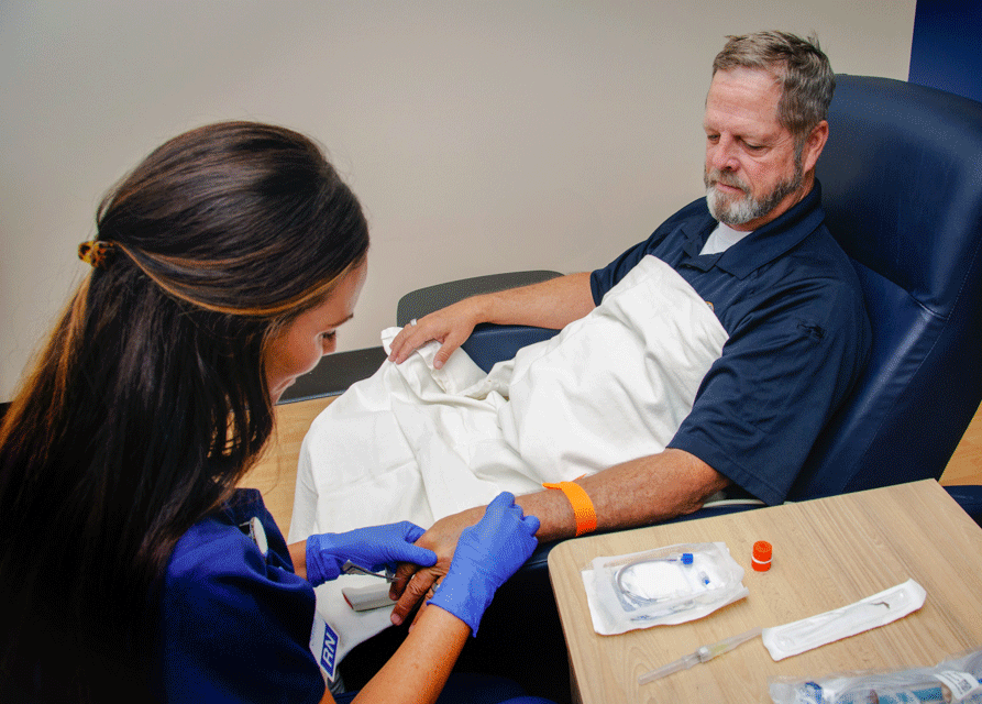 Female MHS nurse preparing mature man for infusion service