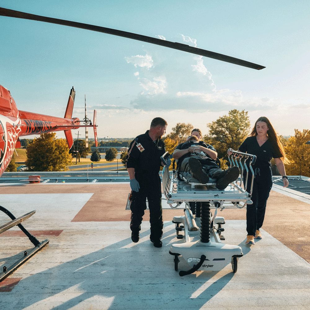 Emergency nurses and EMT bringing patient from helicopter