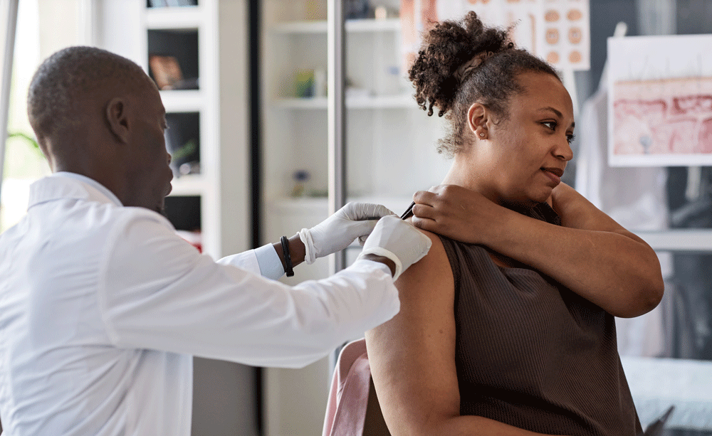 Doctor preparing woman for vaccine in arm