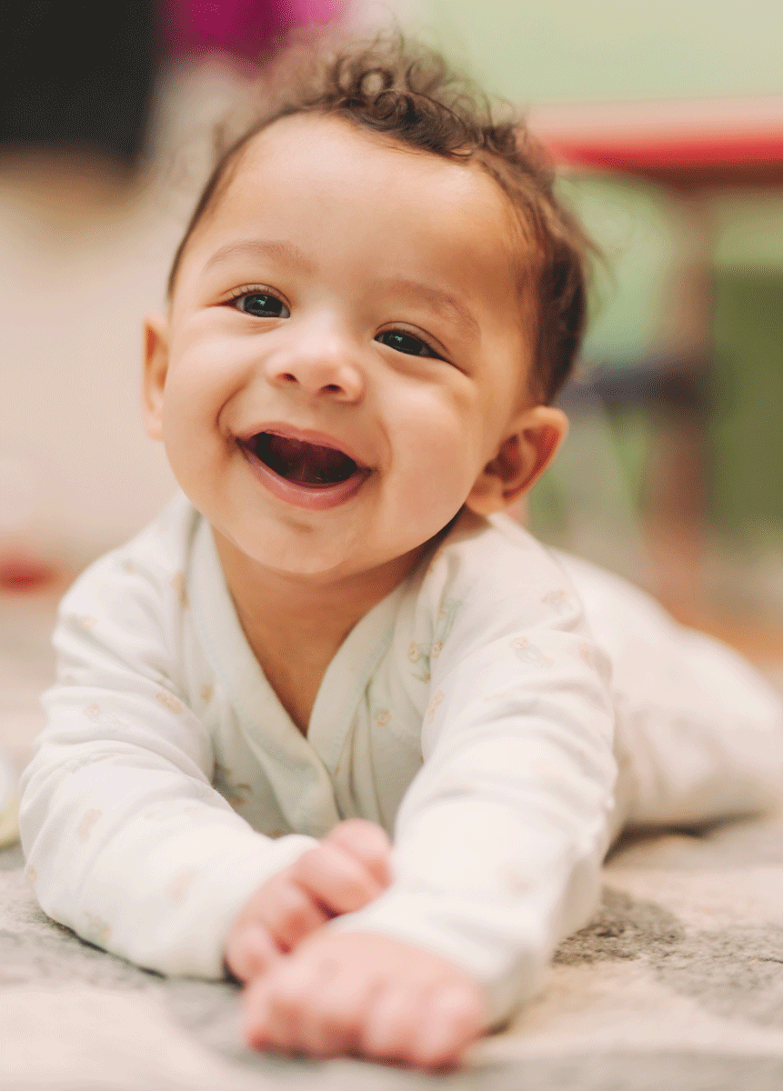 Baby boy smiling on his belly