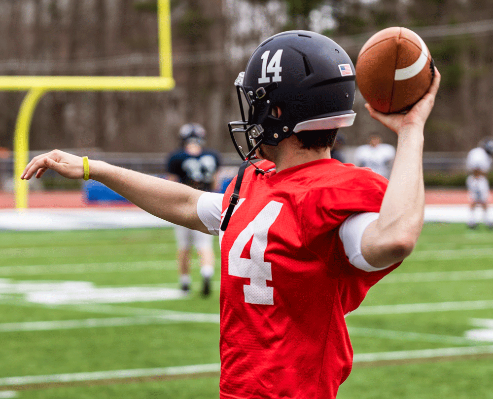 Young football player throwing football