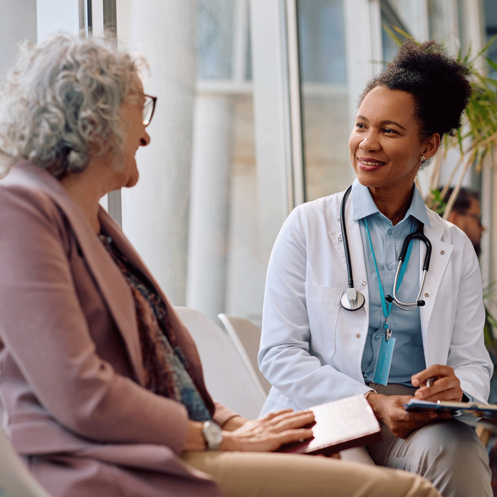 Happy doctor communicating with senior female patient