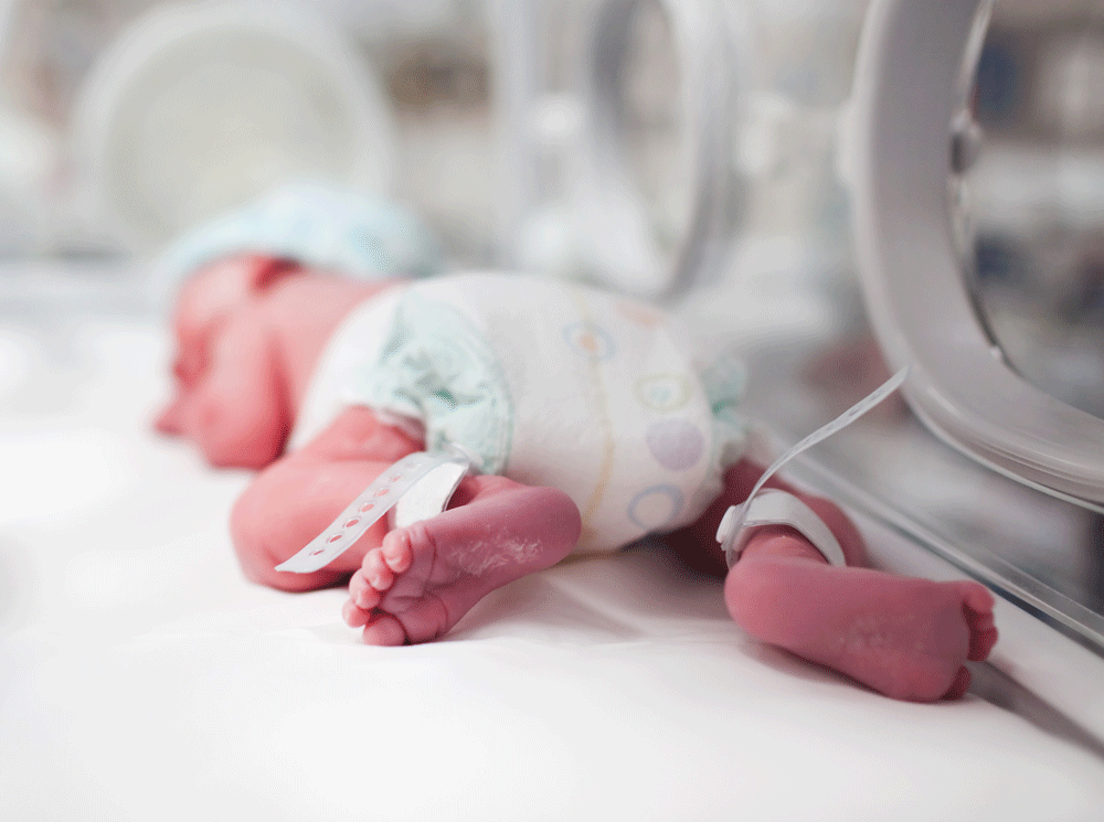 Closeup of feet of newborn in NICU incubator