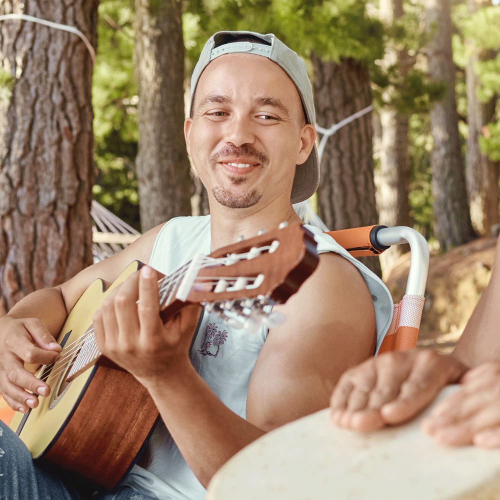 Happy young man playing acoustic guitar