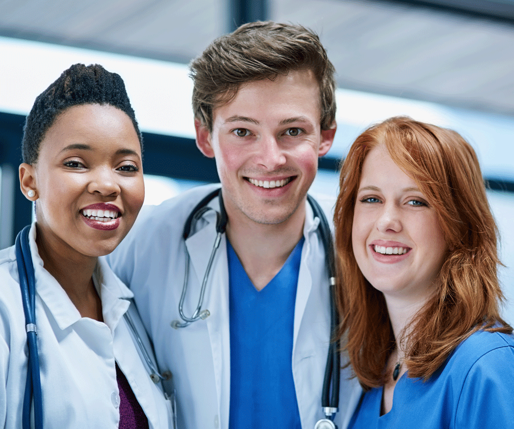 Three young medical professionals smiling at camera