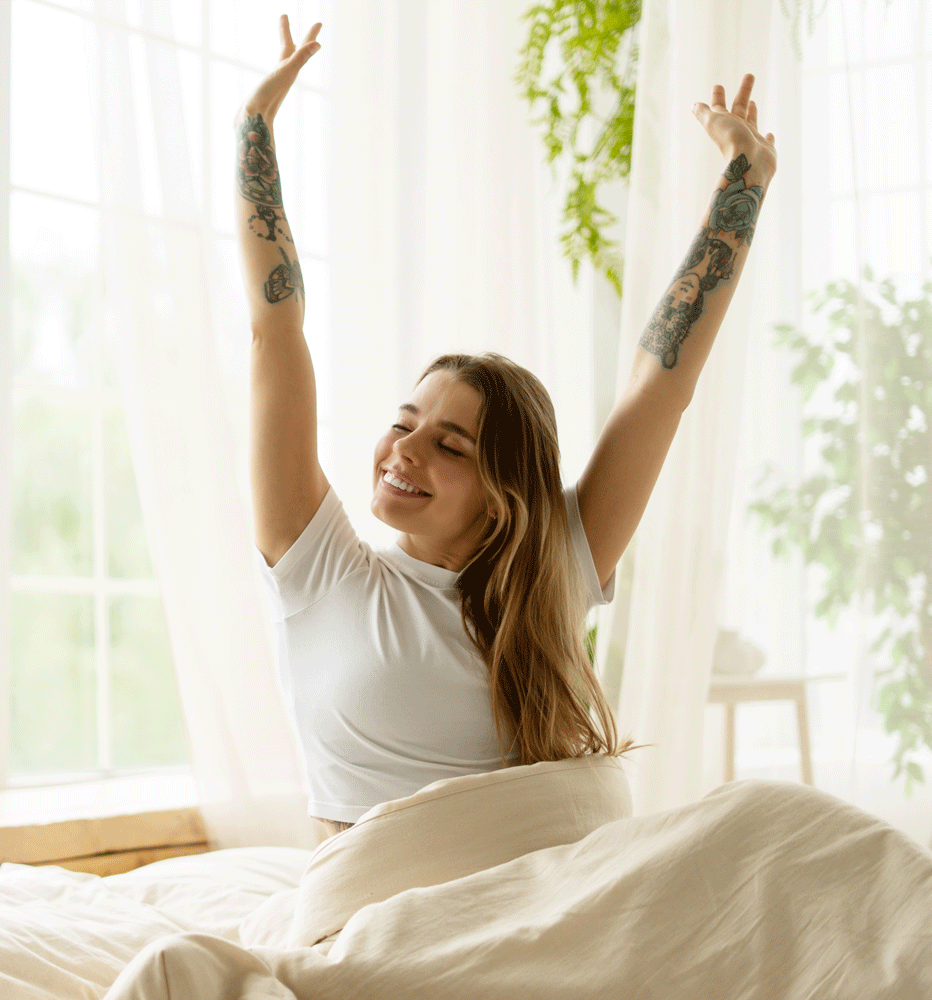 Young woman stretching in bed after waking up
